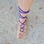 Foot wearing a sandal with interchangeable blue laces on a concrete surface.