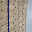 Close-up of textured beige rope surf rug with a blue stringer line running vertically.