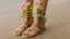 Person wearing sandals on a sandy surface